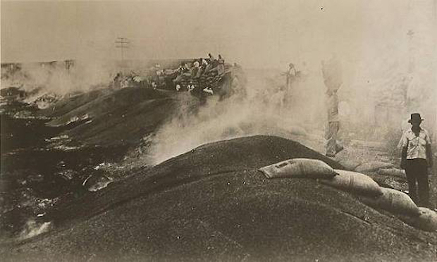 Old postcard from the 1930s 2 – Coffee being unloaded from trains and burned in the port of Santos.